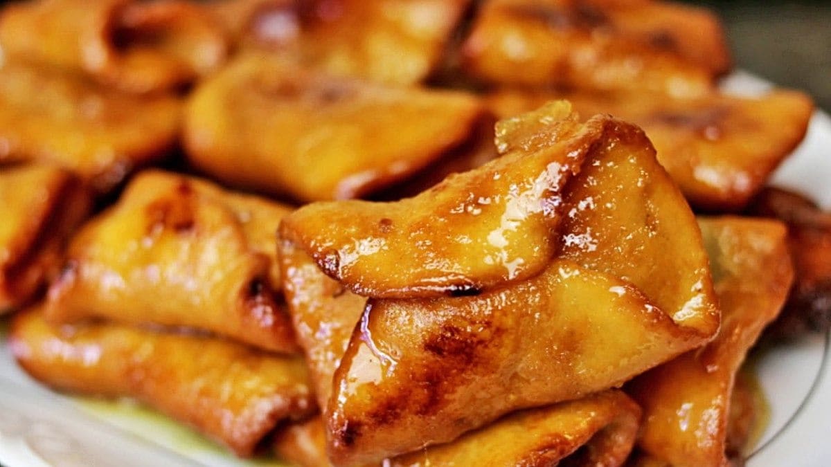 A glistening golden-brown piece of fried dough folded over itself, with more in the background.