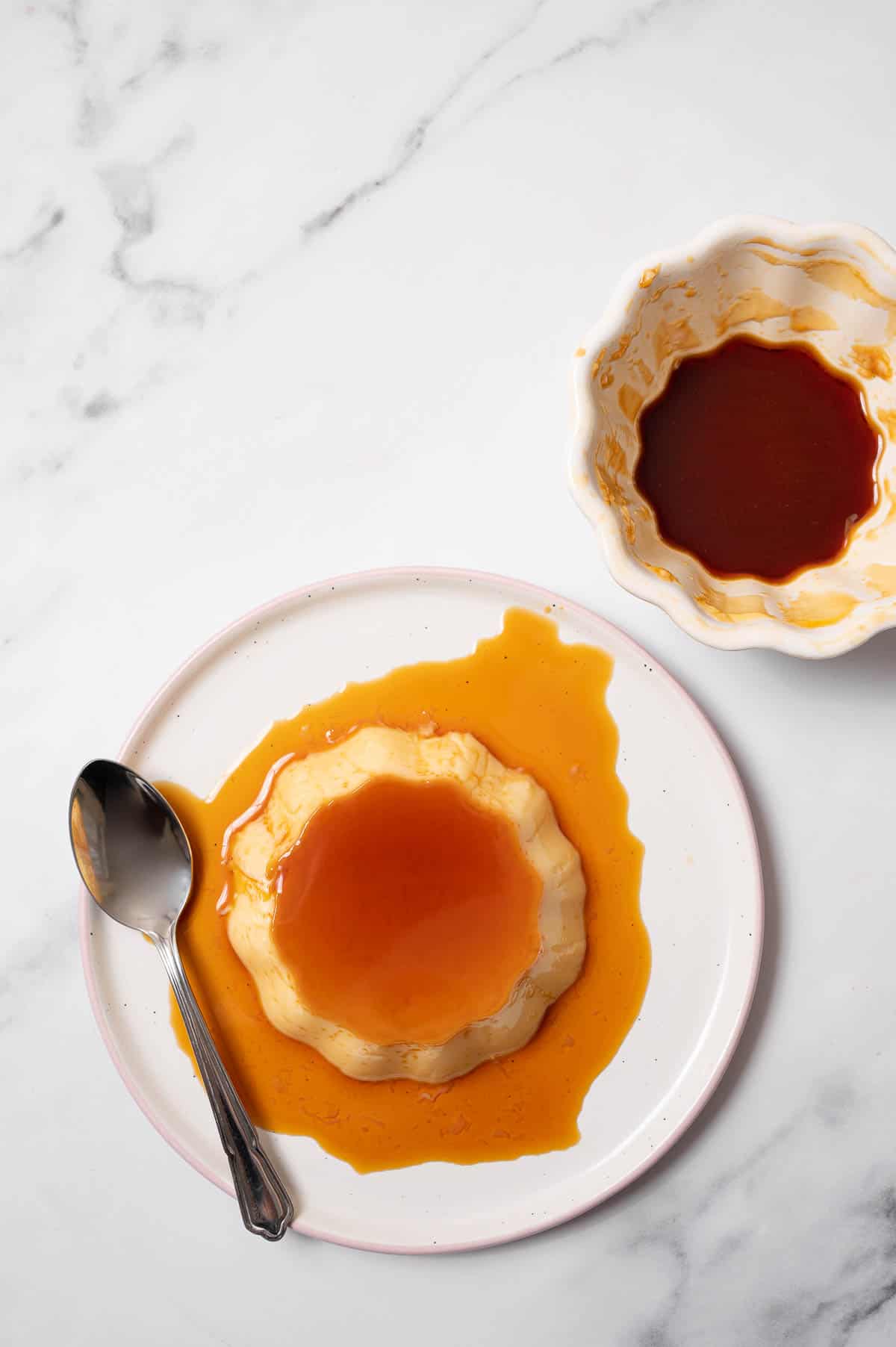 Traditional flan recipe overhead photo of individual sized flan on a white plate with caramel on top