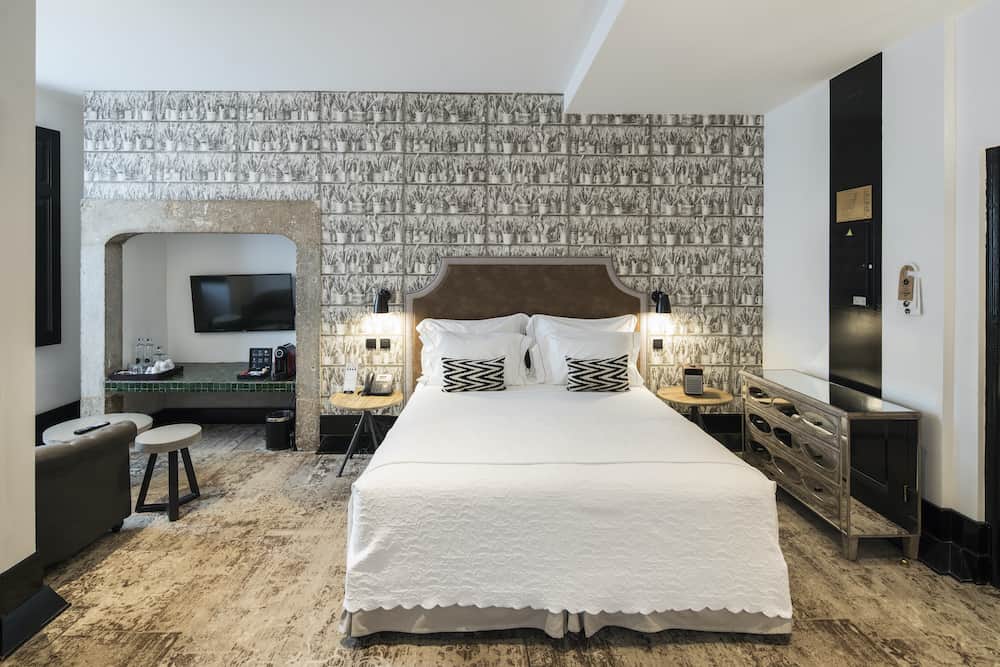 Elegant hotel room decorated in black, white, and silver with a wood floor