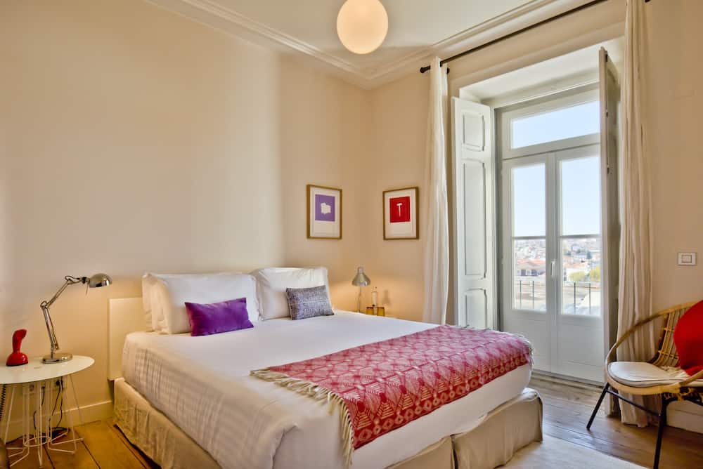 Boutique hotel room with red and purple accents and a French balcony