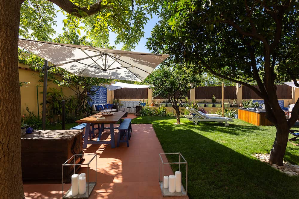 Outdoor space at Geronimo Guest House Belém with a picnic table, trees, and grassy area