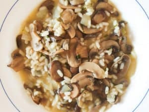 Rice with mushrooms and Manchego cheese in a white bowl.