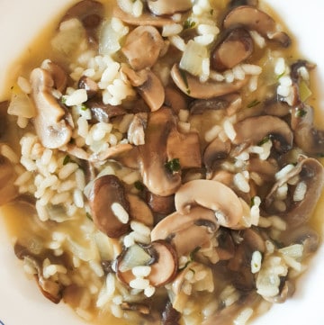 Rice with mushrooms and Manchego cheese in a white bowl.