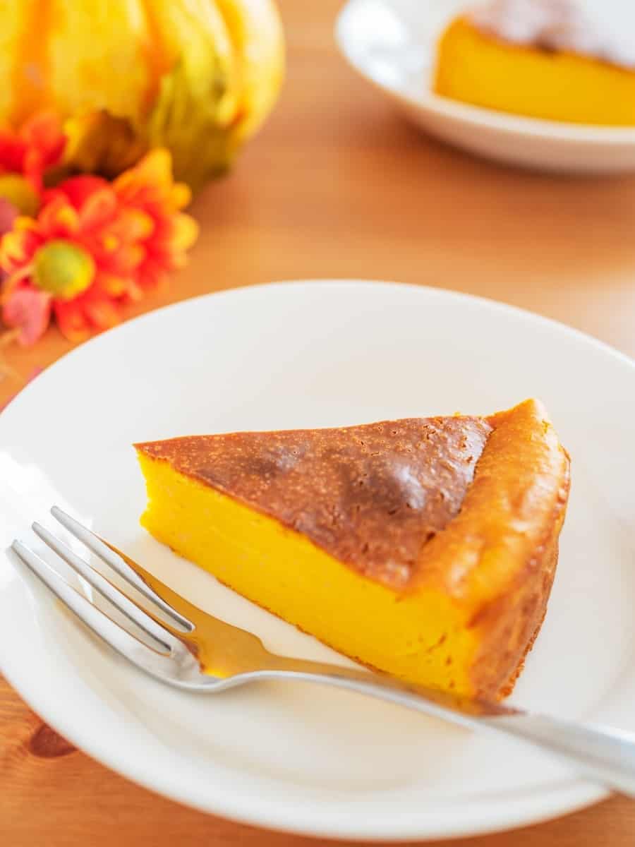 crustless pumpkin cheesecake slice on a white plate with a metal fork
