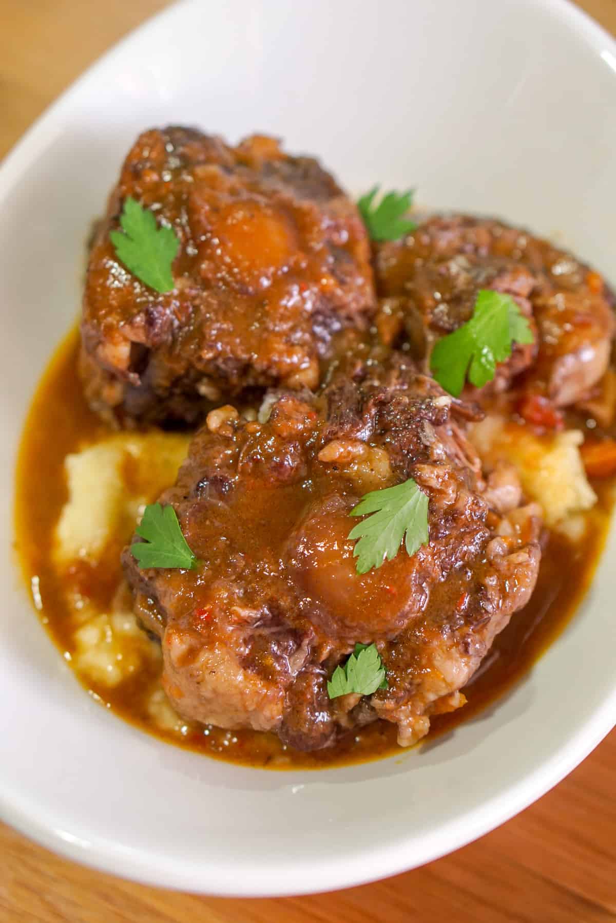 A bowl of Spanish bull tail stew served over mashed potatoes. 