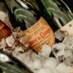 Close up of cava bottles chilling in a bucket of ice.