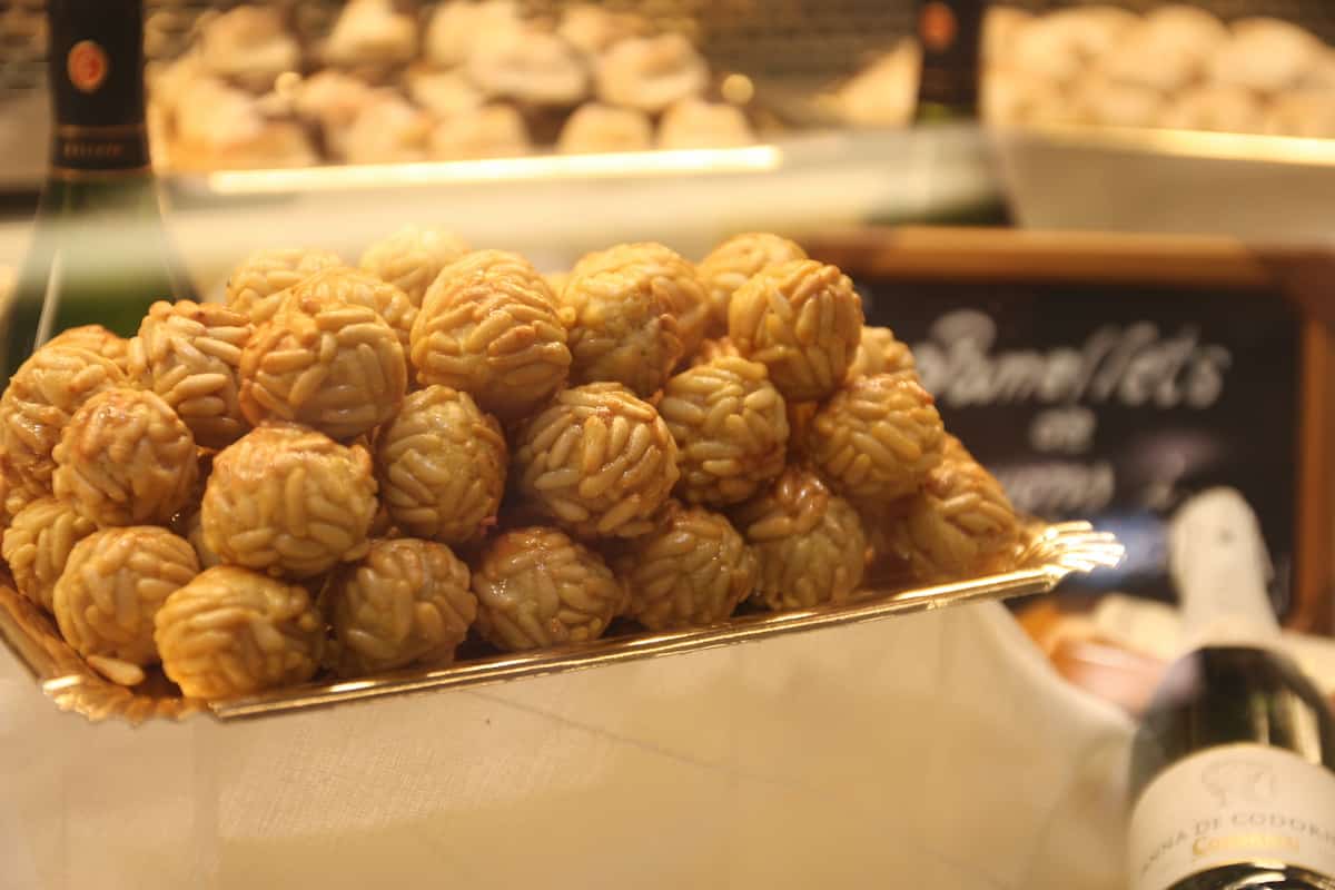 A tray of ball-shaped sweets covered with pine nuts.