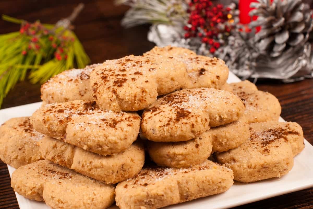 A stack on mantecado cookies on a white plate with decoration in the background