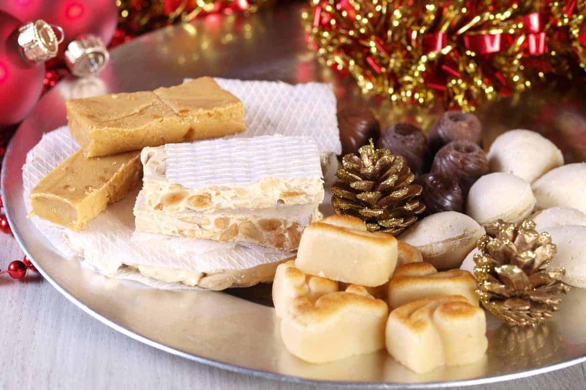 Turron and marzipan on a silver plate with pine cone decoration