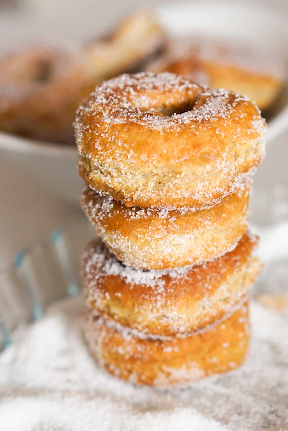 A stacked tower of four sugar covered fried donuts.