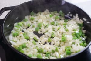 diced onion and peppers in a cast iron skillet