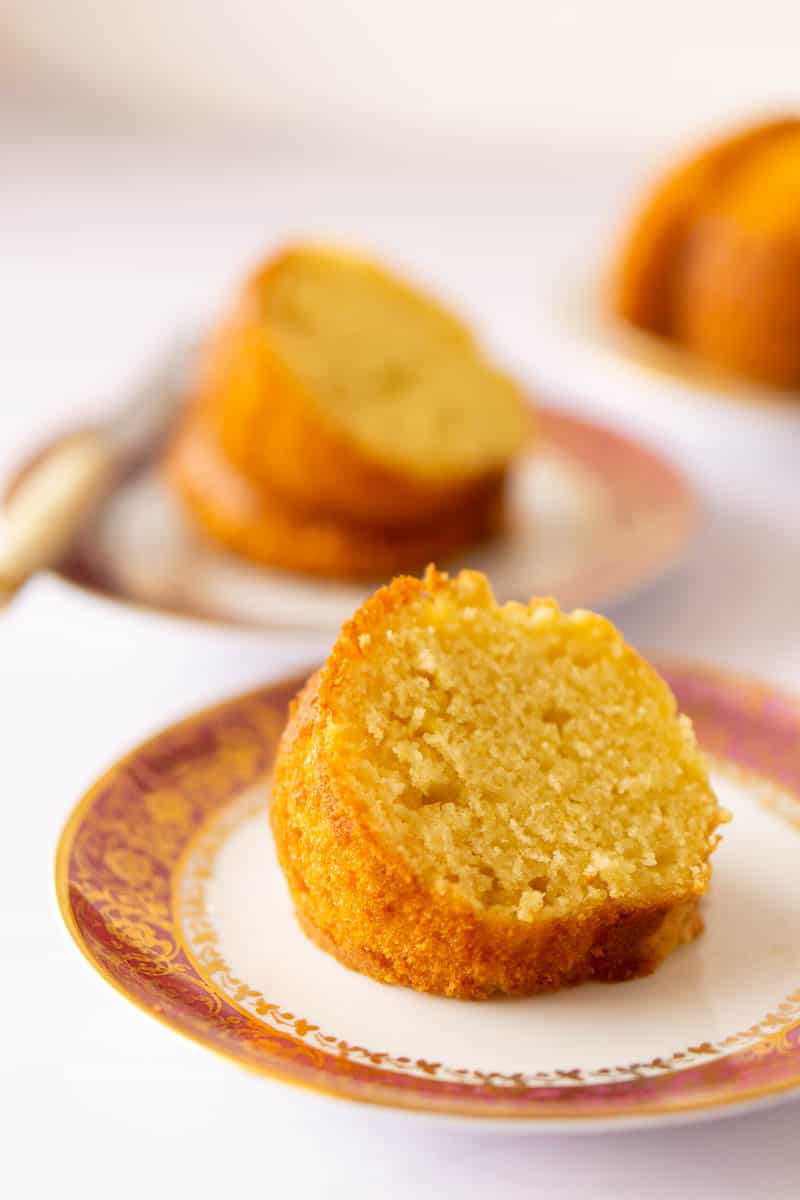 Two slices of Spanish lemon yogurt cake on pretty pink and white plates.