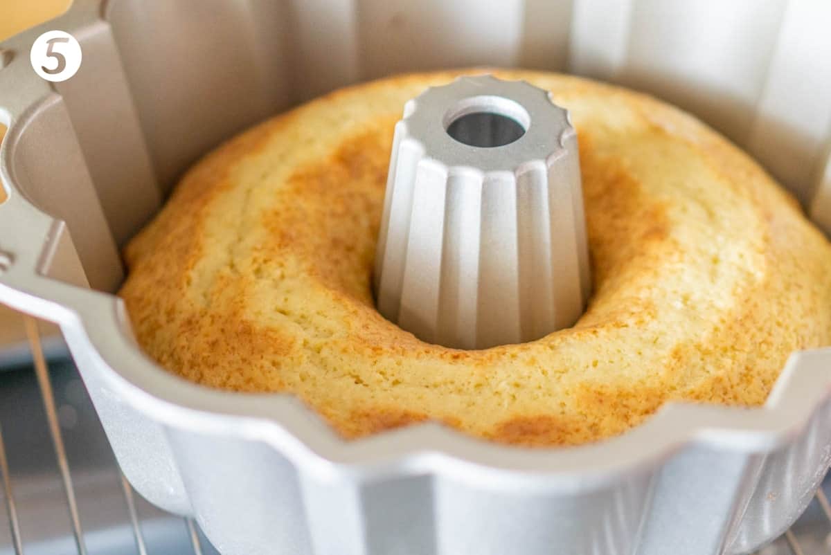 Lemon yogurt cake in a bundt pan on an oven rack.