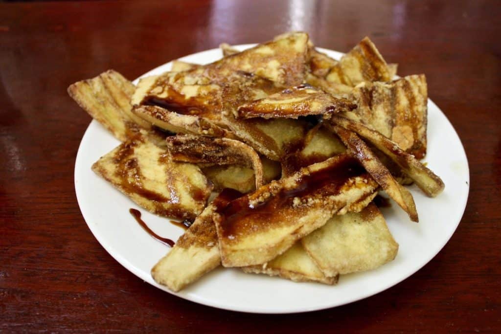 Fried eggplant with molasses on a white plate