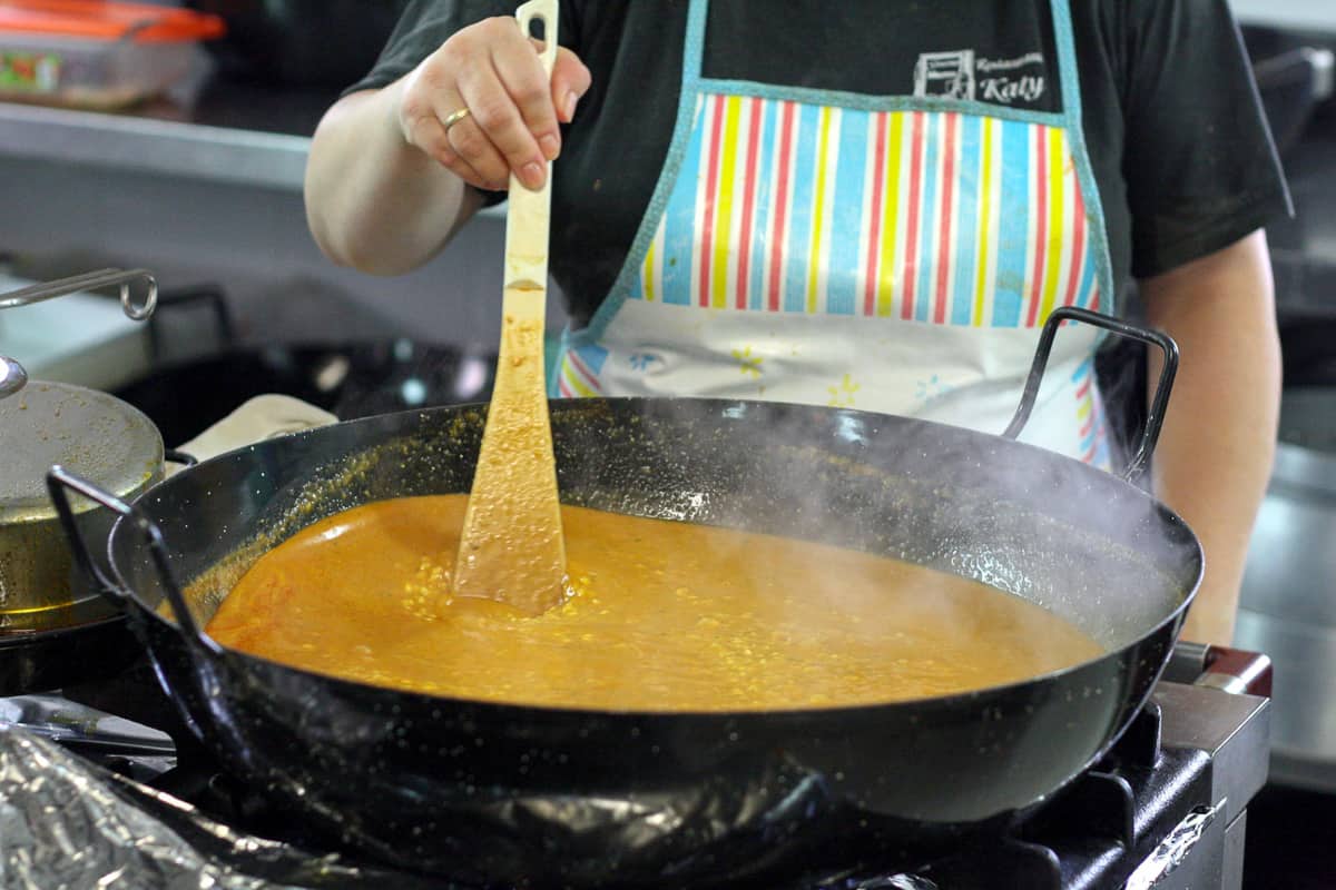 Woman stirring rice in a paella pan inMurcia Spain