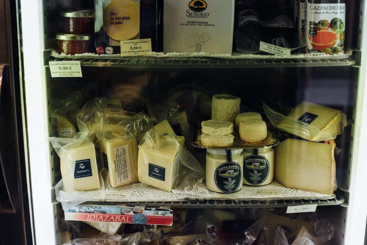 Shelf of local cheeses at a gourmet shop in the Basque Country.
