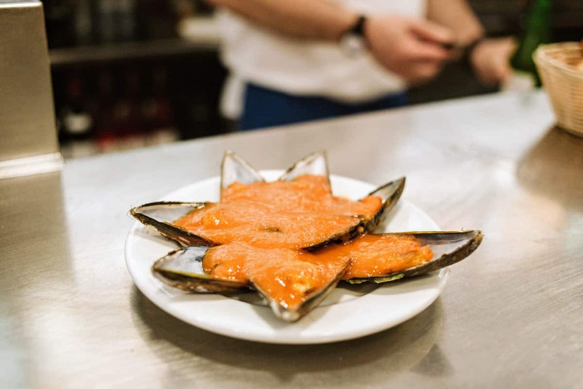 Mussels with tomato sauce on a white plate