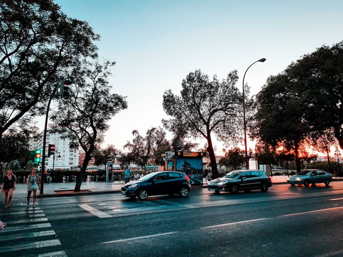 Cars stopped at an intersection on an evening in Seville, Spain