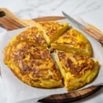 tortilla de patata cut into slices on a cutting board.