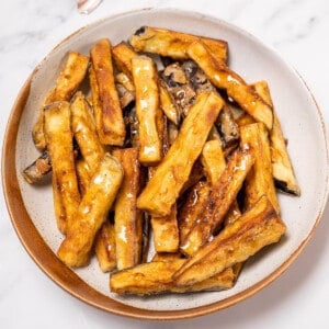plate of golden fried eggplant drizzled with honey.