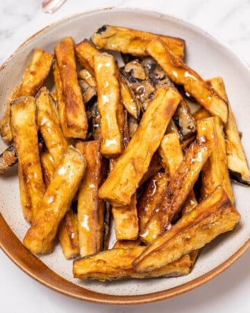 plate of golden fried eggplant drizzled with honey.