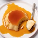 small Spanish flan on a plate with a spoon.