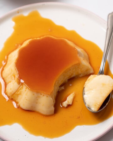 small Spanish flan on a plate with a spoon.