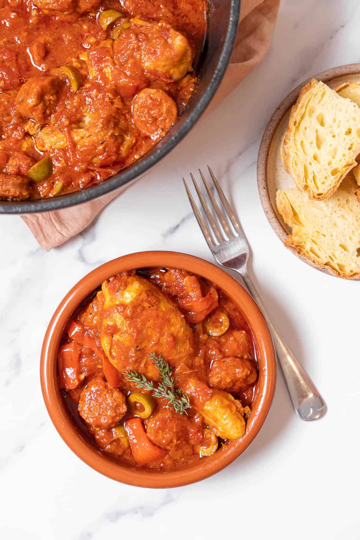 a dish of chicken and chorizo stew with a fork.