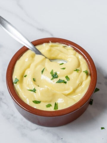 bowl of garlic alioli with a spoon.