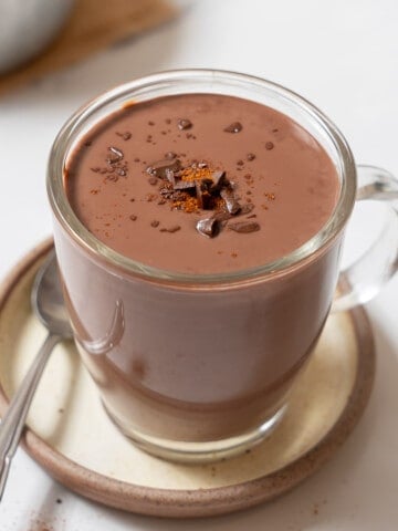 a cup of Spanish hot chocolate with a spoon on a saucer.