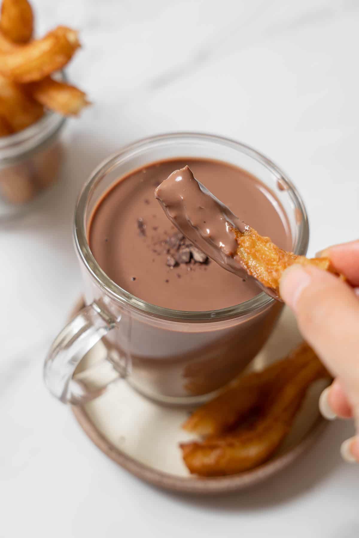 dipping a churro into a cup of Spanish hot chocolate.