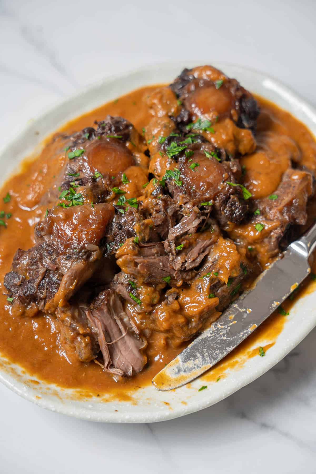 dish of rabo de toro with a knife.