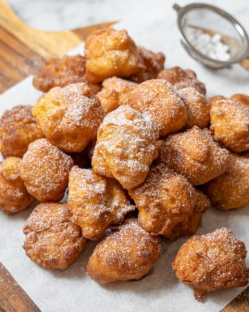 plate of buñuelos dusted with powdered sugar.