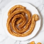 fried churro on a white plate.