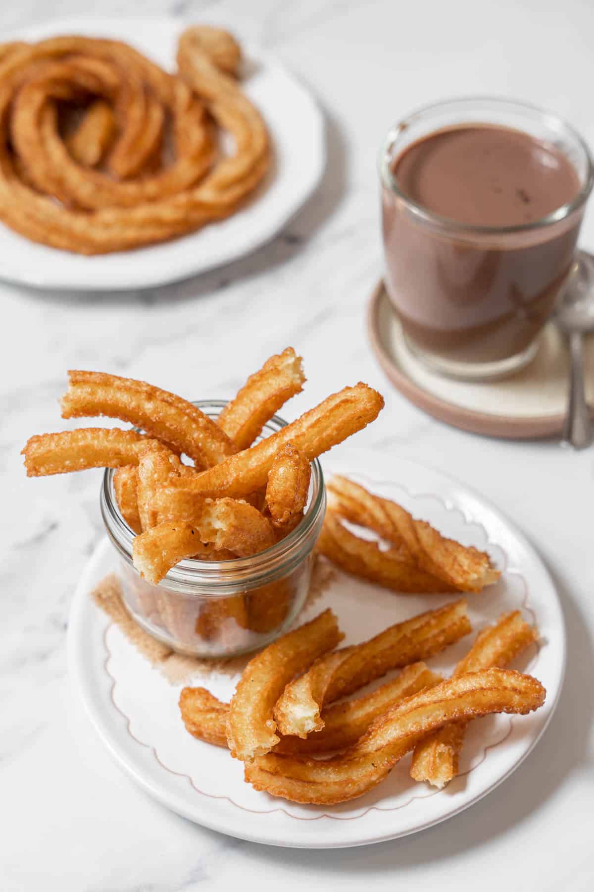 plate of churros with a cup of chocolate.