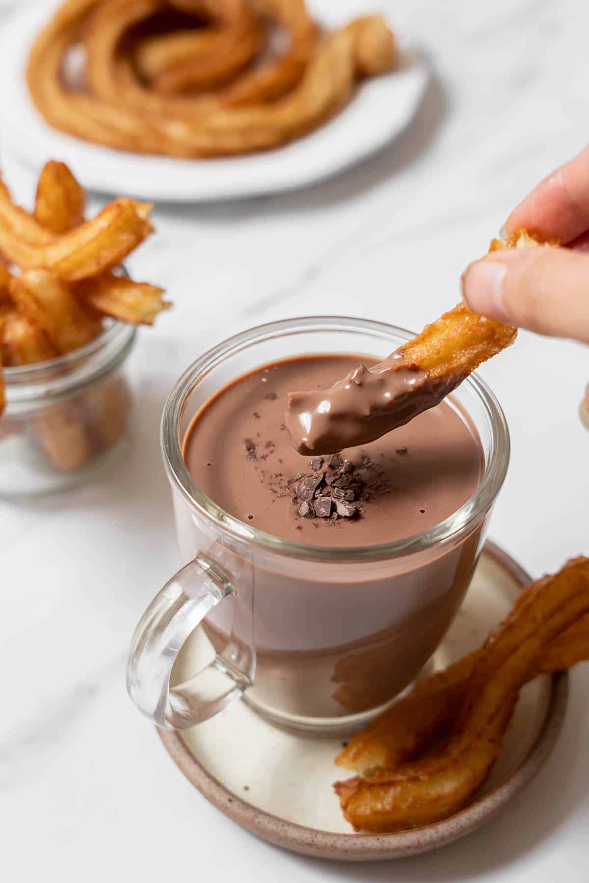 dipping a churro into chocolate.