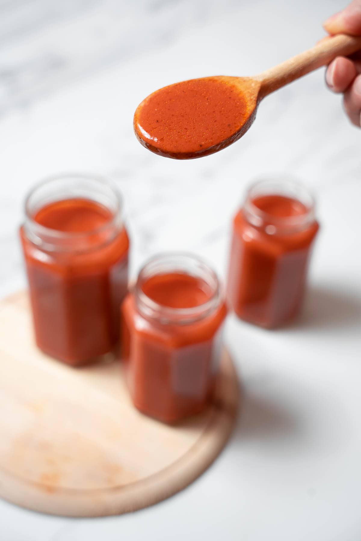 holding a spoonful of salsa de tomate.