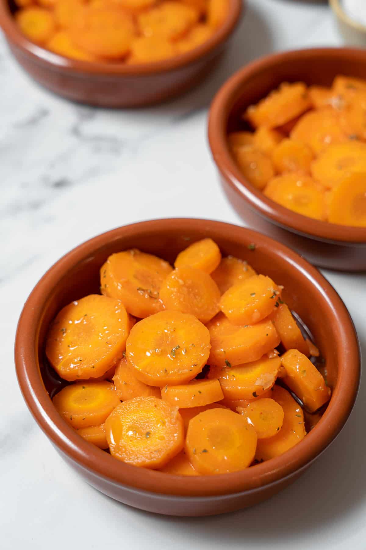 three bowls of marinated carrots.