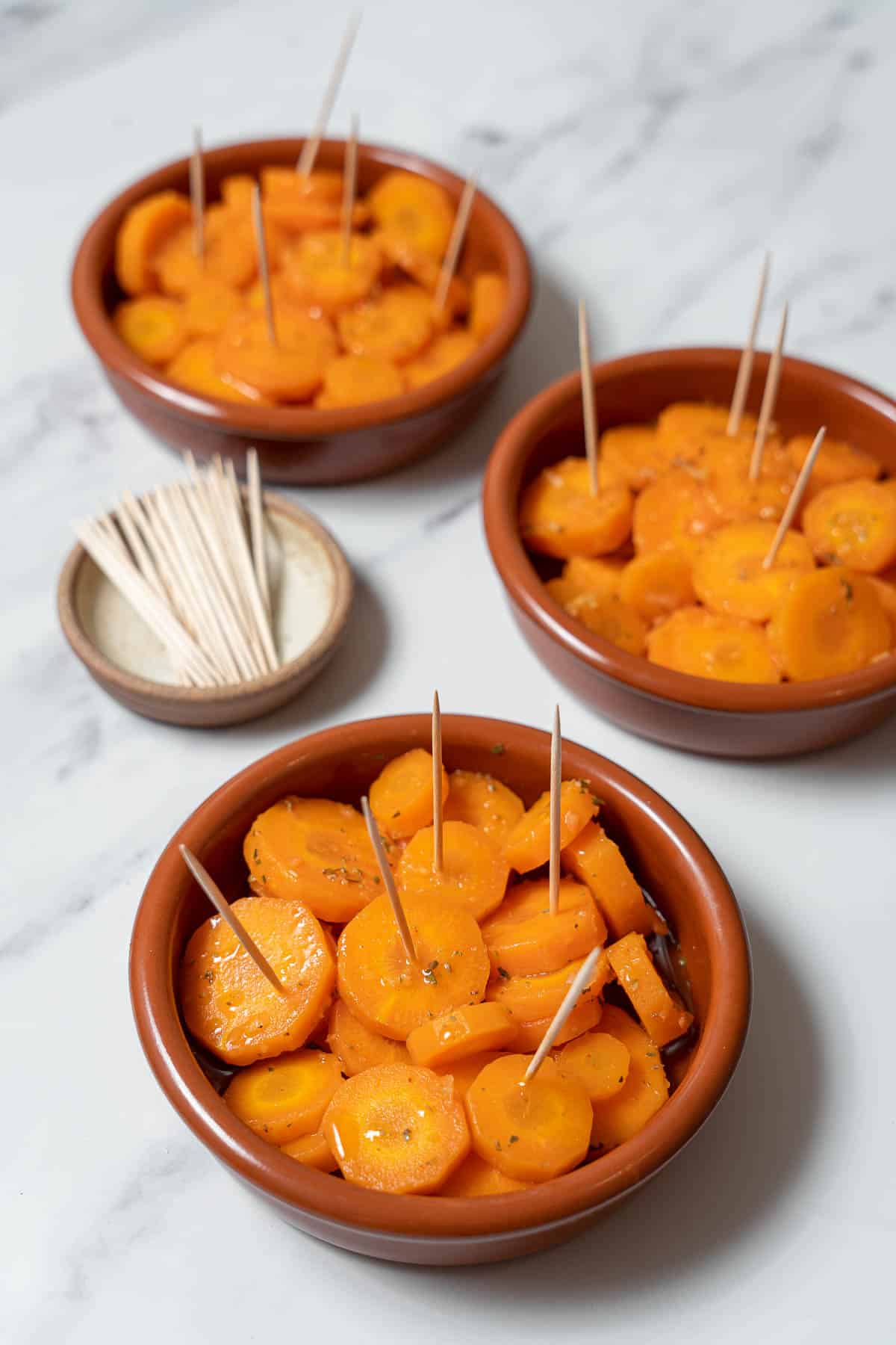 serving marinated carrots with toothpicks.