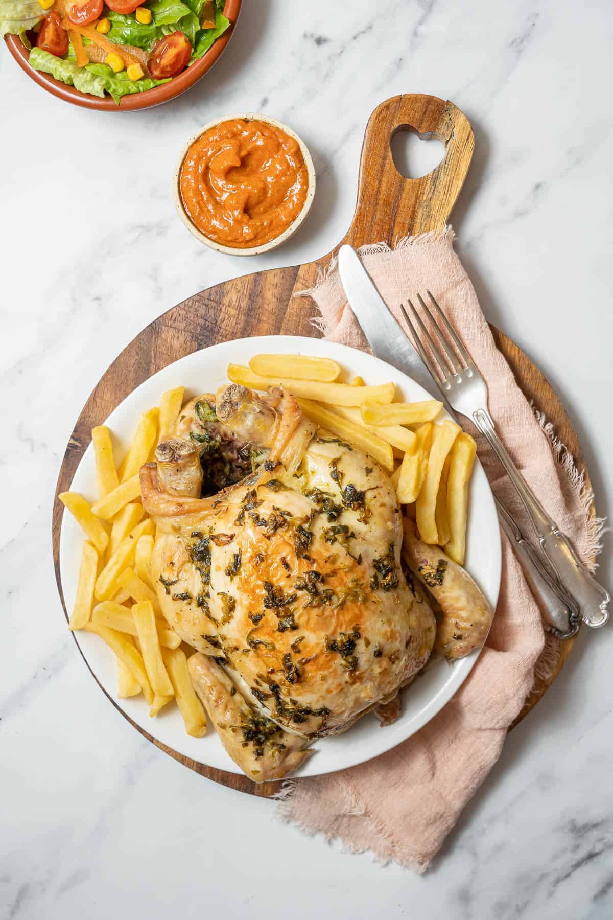 white plate of roasted chicken with fries.