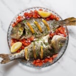 plate of baked bream with tomato salad.