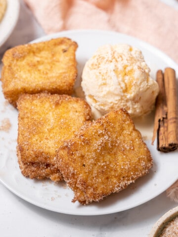 serving the leche frita with ice cream and a cinnamon stick.