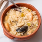 bowl of seafood rice with a spoon.