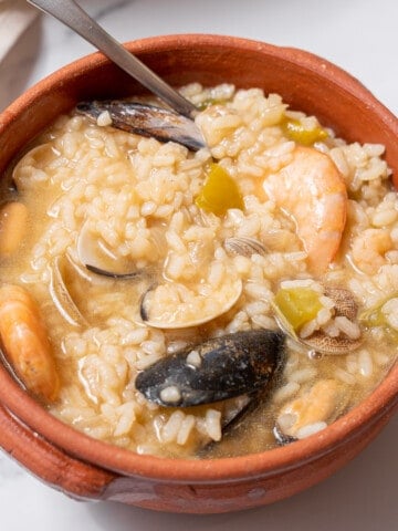 bowl of seafood rice with a spoon.