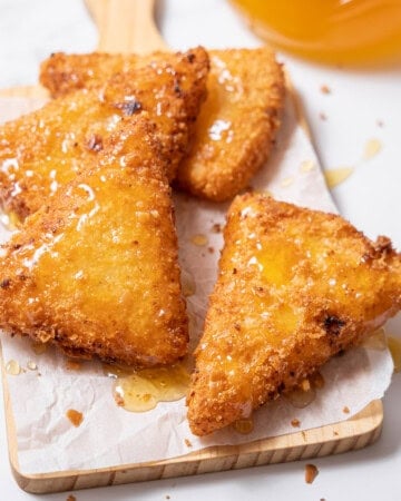 stack of fried goat cheese pieces with honey.