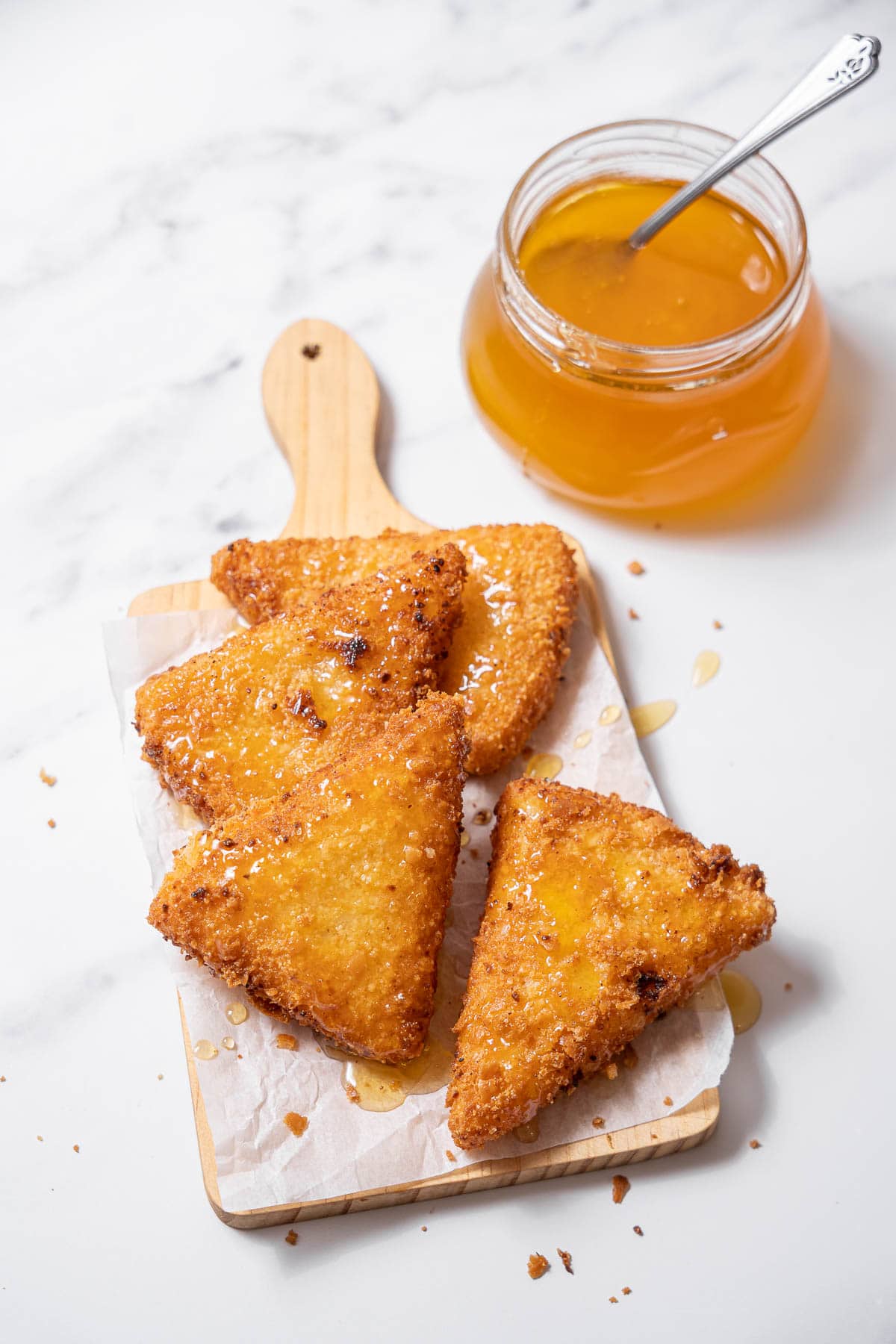 four slices of fried goat cheese with honey.