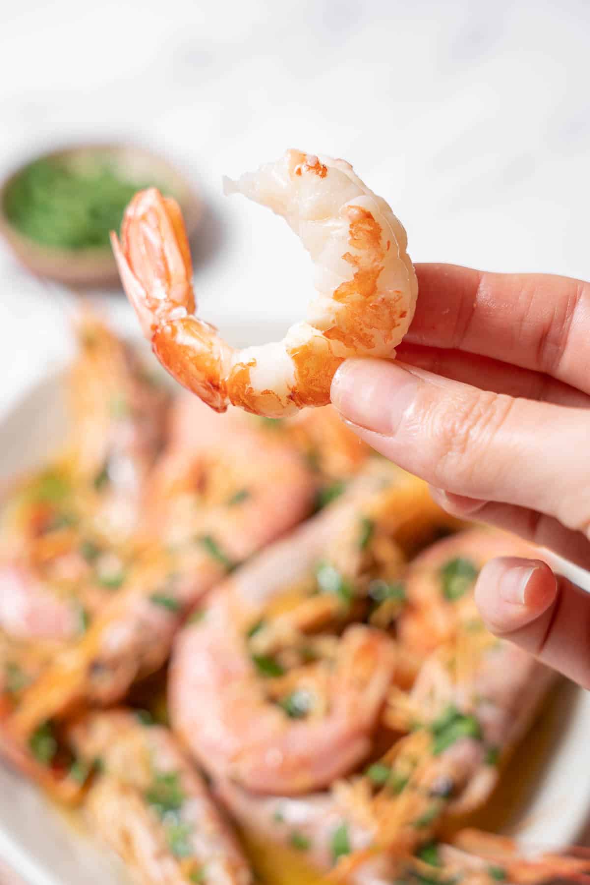 holding a peeled shrimp in whiskey sauce.