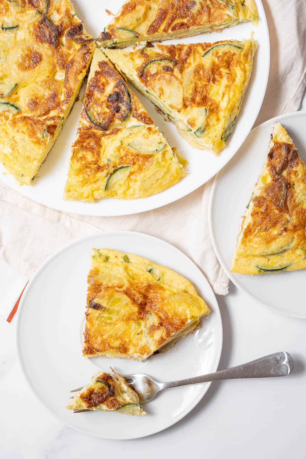 sliced Spanish tortilla with zucchini with a fork.