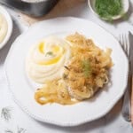 plate of hake with onions and dill.