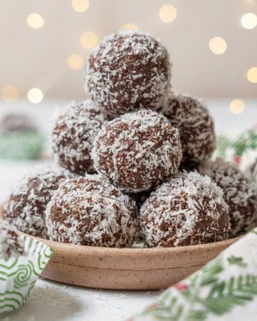 stack of chocolate coconut balls on a plate.